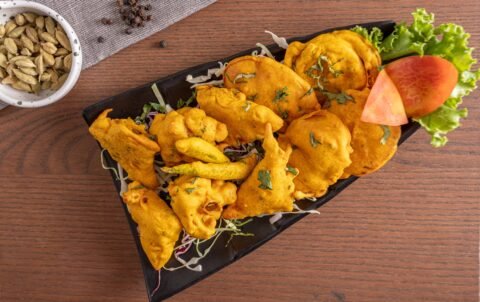Crispy mix vegetable pakora fritters with green chilli at Tandoori Smoke Indian restaurant Bangkok