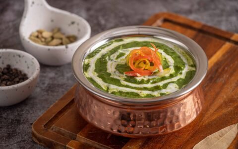 Palak paneer spinach curry with cream in a copper handi at Tandoori Smoke Indian restaurant Bangkok